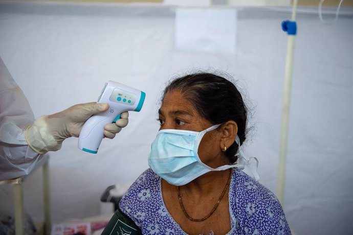 Toma de temperatura a una mujer en India durante la pandemia de coronavirus