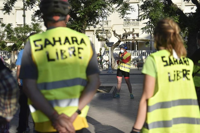 Participantes en la marcha en bicicleta en apoyo al pueblo saharaui esperan el inicio del evento, a 30 de mayo de 2021, en Huesca (Aragón). Portan chalecos reflectantes que dicen 'Sahara libre'.