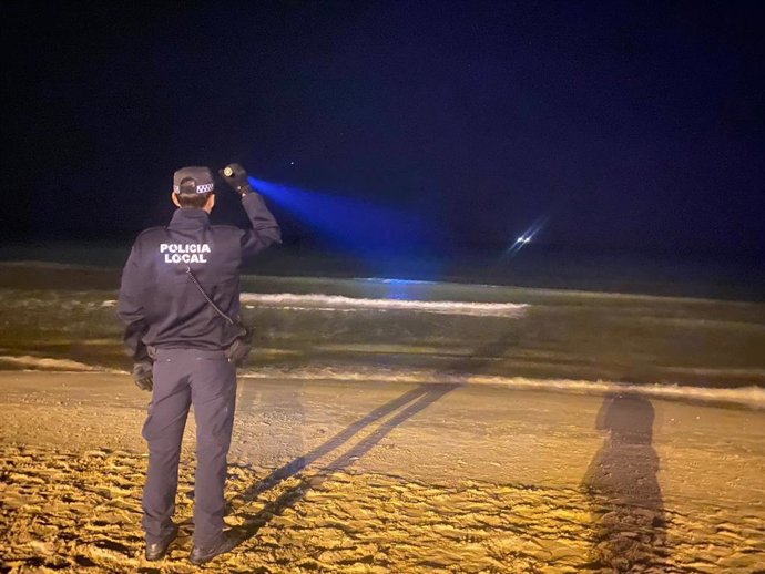 Archivo - Un agente de la Policía Local de Alicante busca una patera, en un imagen de archivo