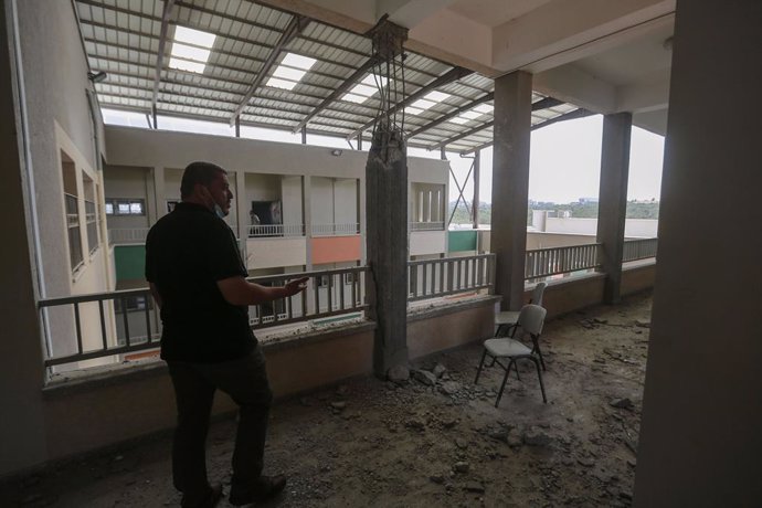 30 May 2021, Palestinian Territories, Gaza City: An employee of the Palestinian Ministry of Education inspects one of the damaged corridors of a school that was hit during the recent Israeli airstrikes on the Zeitoun neighbourhood in Gaza City. Israel a