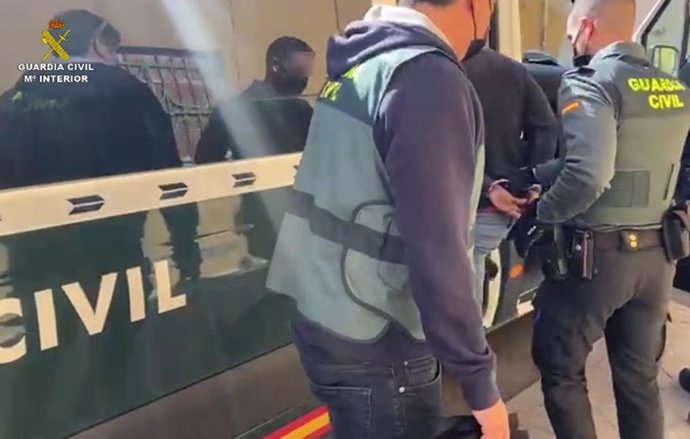 Agentes de la Guardia Civil introduciendo a uno de los detenidos en uno de sus vehículos