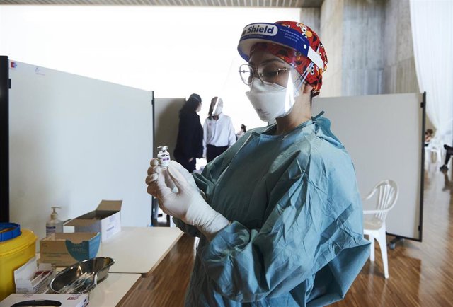 Archivo - Una profesional sanitaria sostiene un vial con la vacuna de AstraZeneca en el Palacio de Exposiciones y Congresos de Santander.