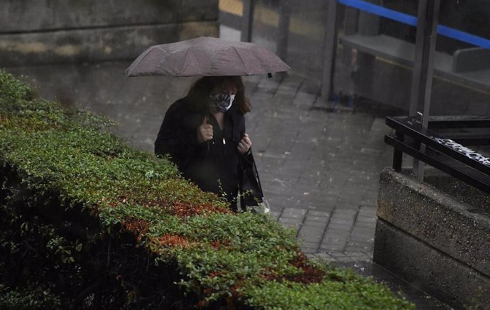 Archivo - Una persona camina bajo la lluvia protegida con un paraguas, en Madrid (España) a 24 de septiembre de 2020. La ciudad ha registrado un chubasco intenso este jueves entre las 08.30 y las 10.00 horas en el que se han acumulado entre 17 y 19 litr