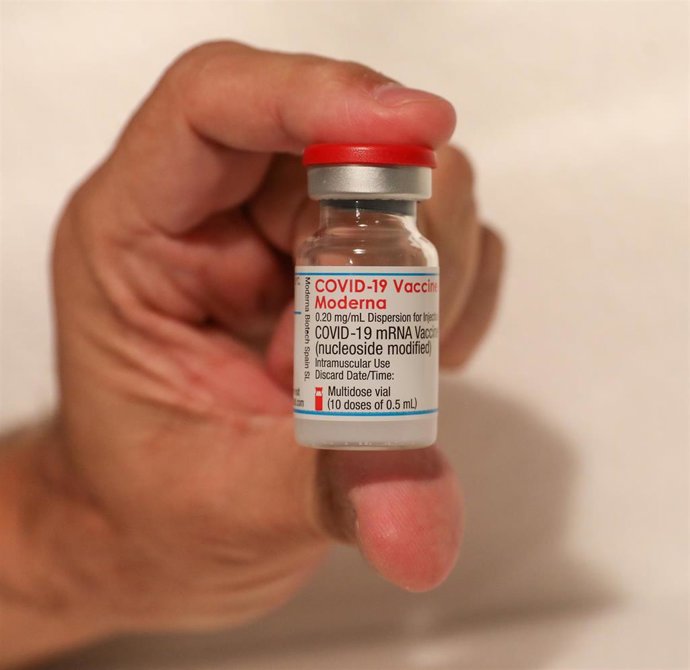 Una persona sostiene un vial de la vacuna de Moderna contra el Covid-19.