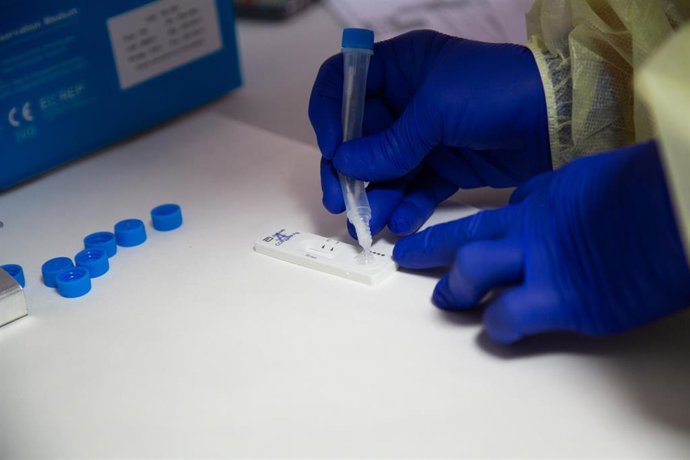 Archivo - Una sanitaria comprueba el resultado de un test de antígenos. 