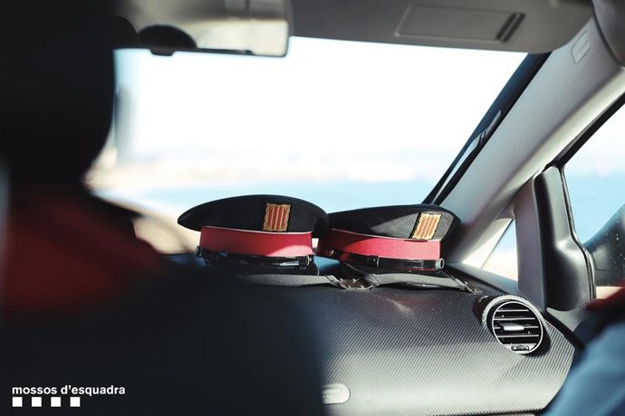 Archivo - Dos gorras en un vehículo de Mossos d'Esquadra (ARCHIVO).