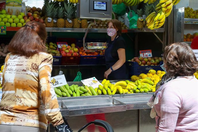 Archivo - Una trabajadora de una frutería del Mercado Central de Valencia atiende a dos clientas después de que el Ministerio de Sanidad autorizara a que la totalidad de la Comunidad Valenciana pasase en su conjunto a la fase 1 de la desescalada, en Val