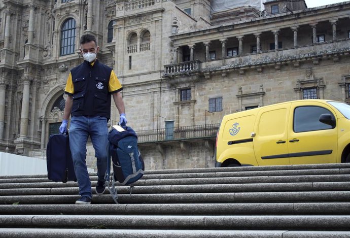Trabajador de Correos portando mochilas de peregrinos del Camino de Santiago.