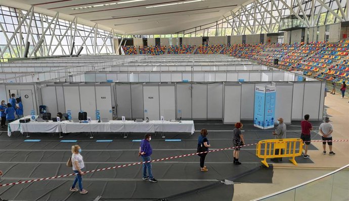 Usuarios esperando para recibir la vacuna en la Pista Cubierta de atletismo de Sabadell.