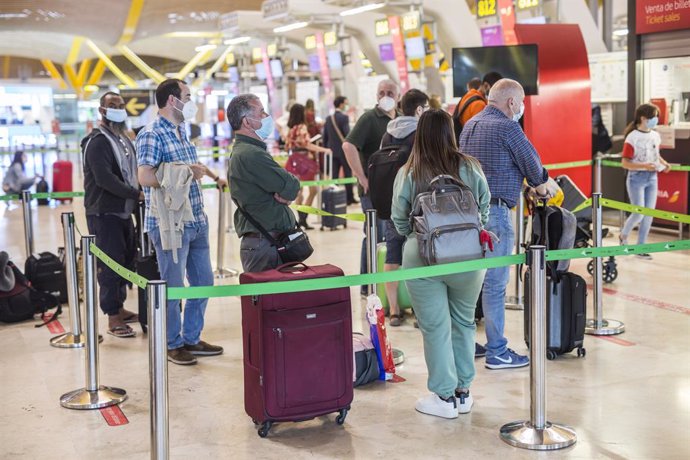 Varias personas hacen fila con maletas en la terminal T4 del Aeropuerto Adolfo Suárez Madrid-Barajas, a 21 de mayo de 2021. El presidente del Gobierno, ha anunciado este viernes que España permitirá a partir del próximo 7 de junio la entrada a los viaje