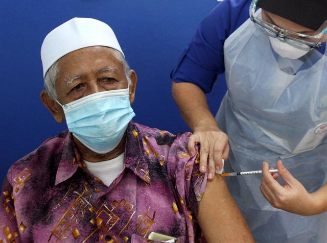 Arxiu - Un professional sanitari vacuna un home contra la covid-19 a Malàisia.