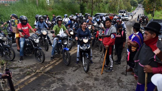 14 May 2021, Colombia, Piendamo: Pedestrians and moped riders stand in front of the barricades that block the Panamericana highway during a protest against the government of Colombian President Ivan Duque Marquez. Photo: Christian Escobar/dpa