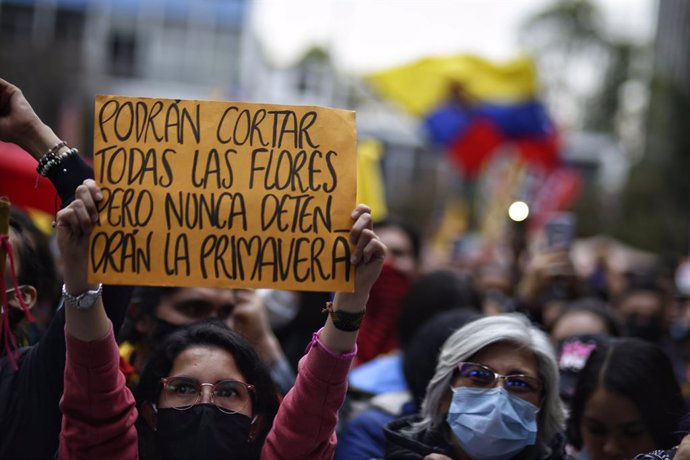 28 May 2021, Colombia, Bogota: A woman holds a placard saying "Maybe they can cut away all the flowers, but they will never stop the spring," during a protest against the government of President Ivan Duque Marquez. Photo: Sergio Acero/colprensa/dpa