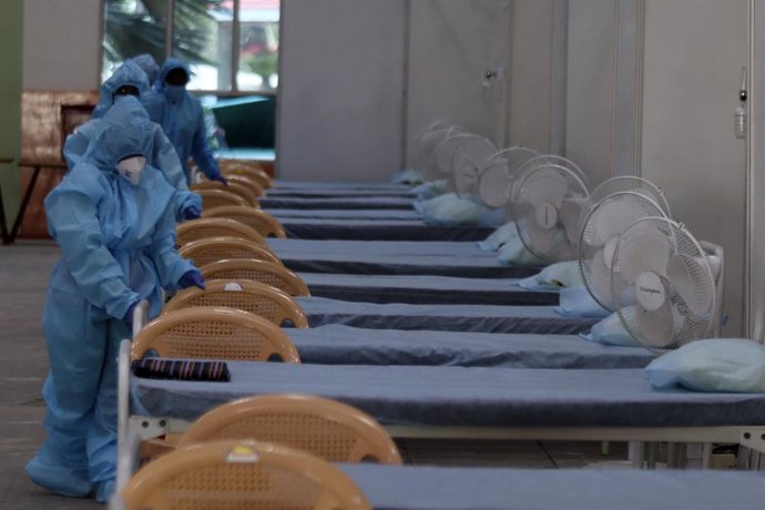 Trabajadores sanitarios preparan un hospital de campaña en un estadio en India ante la pandemia de coronavirus