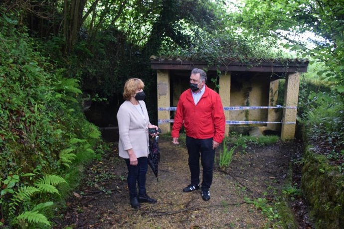 El concejal Alejando Villa con la vecina de Limanes, Estrella Sánchez, en la fuente Fornos Vieyos de Limanes.