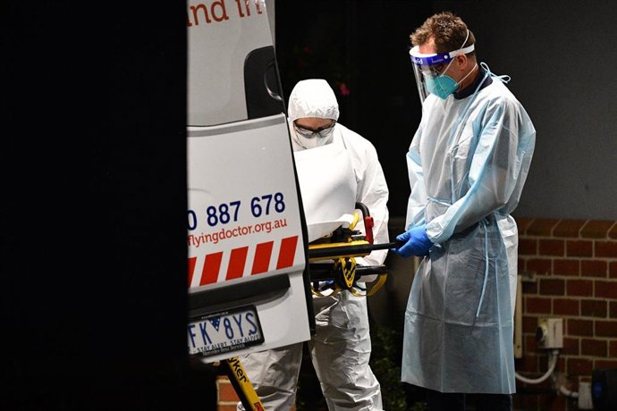Trabajadores sanitarios trasladan a un paciente de COVID-19 en Melbourne.