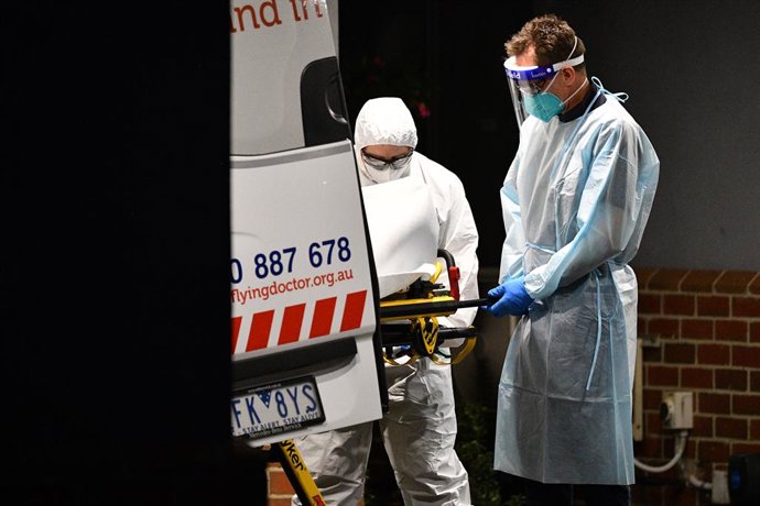 Trabajadores sanitarios trasladan a un paciente de COVID-19 en Melbourne.