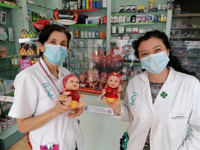 Cristina Gervasini, farmacéutica titular, y Mamen Ridruejo, farmacéutica adjunta, con los Baby Pelones de Juegaterapia.