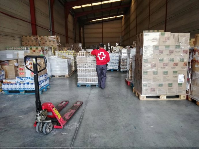 Archivo - Un voluntario de Cruz Roja participa en el reparto de alimentos