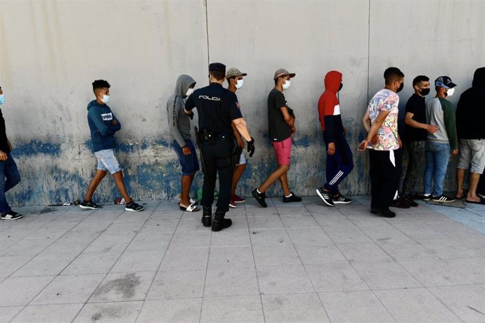 Varios migrantes procedentes de Marruecos hacen cola en las puertas de la frontera de Ceuta