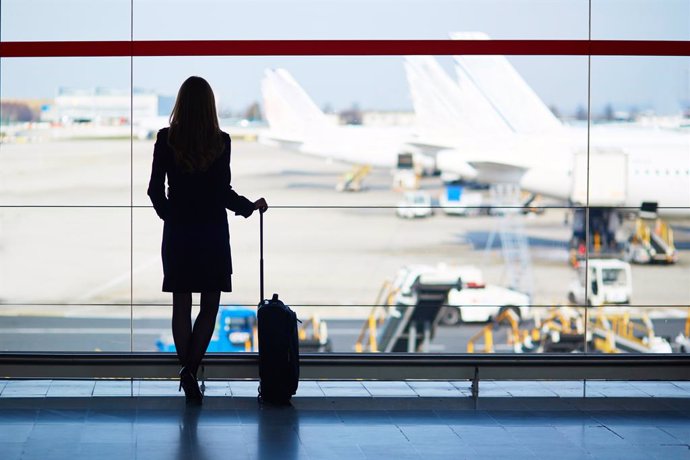 Archivo - Viajera frente a una ventana en un aeropuerto.