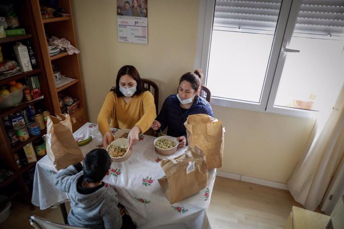 Archivo - Dos mujeres y un niño comen en su casa en Madrid.