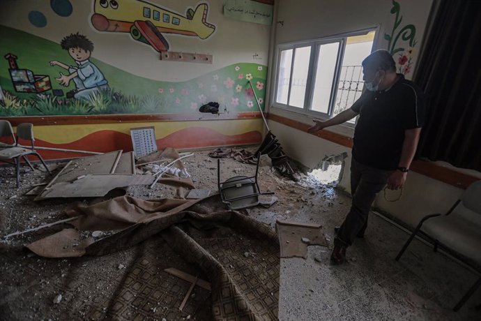 30 May 2021, Palestinian Territories, Gaza City: An employee of the Palestinian Ministry of Education inspects a damaged classroom inside a school that was hit during the recent Israeli airstrikes on the Zeitoun neighbourhood in Gaza City. Israel and th