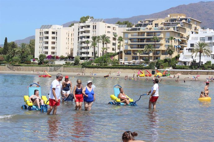 Archivo - Personas con movilidad reducida se bañan en una playa de Estepona gracias al servicio de baños asistidos