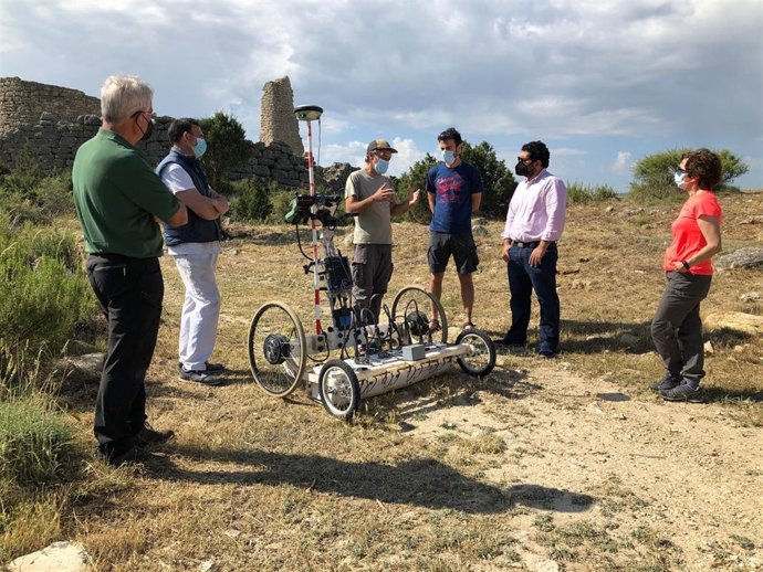 Diego Piñeiro y los directores de la excavación con el alcalde y concejal de Oliete y los miembros de la empresa del prospecciones junto a la máquina de prospección.