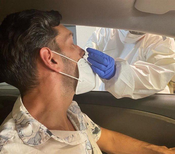 Un sanitario toma muestras a un hombre para hacer una PCR