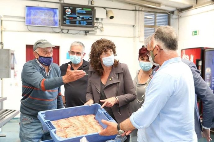 La consellera Jord visitando la lonja de Rosas acompañada de los patrones de las barcas de arrastre