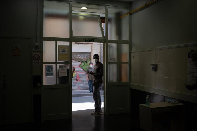 Un hombre espera en la puerta del centro abierto de la Fundació Arrels, el día de la jornada de vacunación a personas sin hogar, a 3 de junio de 2021, en Barcelona, Cataluña (España).