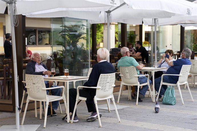 Varias personas en la terraza de una cafetería de Móstoles el mismo día en que la Comunidad de Madrid ha indicado que a partir del próximo lunes, 31 de mayo, disminuirán las restricciones en este sector, a 26 de mayo de 2021, en Móstoles, Madrid, (Españ