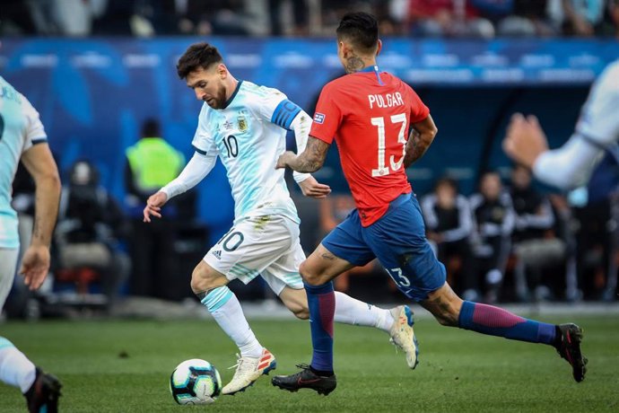 Archivo - Leo Messi intenta zafarse de Erik Pulgar en un Argentina-Chile