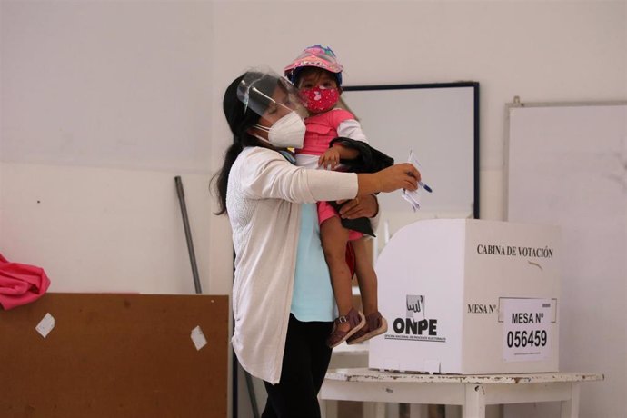 Archivo - Una mujer deposita su voto en la primera vuelta de las elecciones en Perú