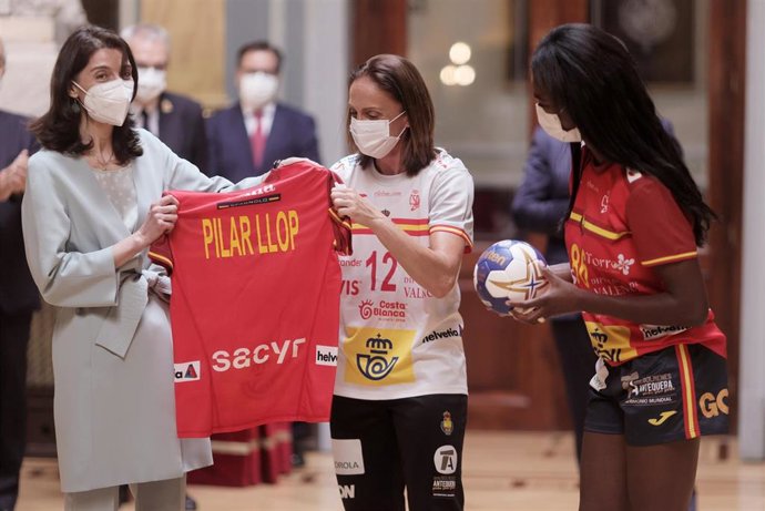 La presidenta del Senado, Pilar Llop (i), recibe una camiseta de la selección española femenina de balonmano de manos de las jugadoras Shandy Barbosa y Silvia Navarro