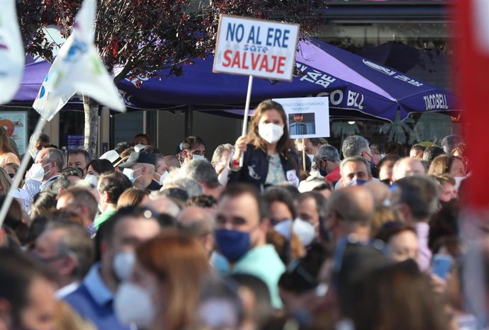 Una mujer con un cartel en el que se lee: "No al ERE salvaje" durante una concentración contra el ERE de Caixabank en las Torres Kio de Plaza de Castilla, a 20 de mayo de 2021, en Madrid (España).