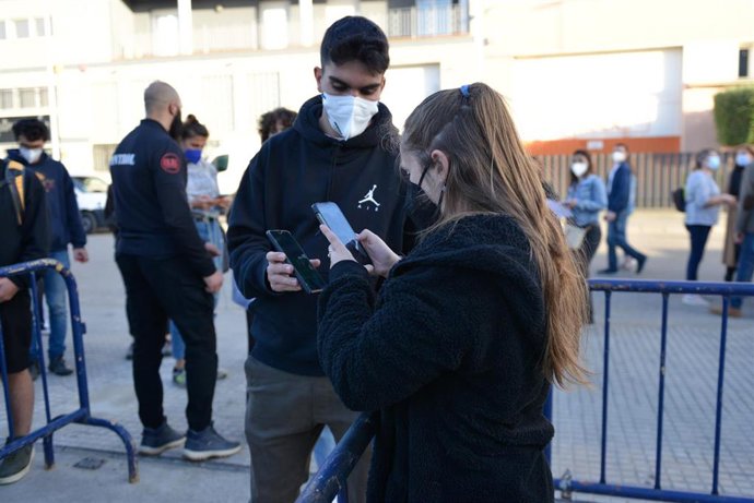 Un hombre enseña su entrada para un concierto.