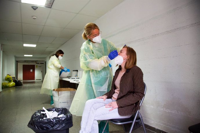 Archivo - Una sanitaria realiza un test de antígenos o una PCR a una mujer, en un dispositivo de cribado masivo instalado en el Hospital Perpetuo Socorro, en Badajoz, Extremadura (España), a 1 de abril de 2021. Este miércoles ha comenzado la segunda fas