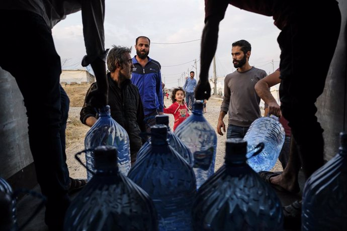Archivo - Reparto de garrafas de agua entre refugiados en Irak, en octubre de 2019