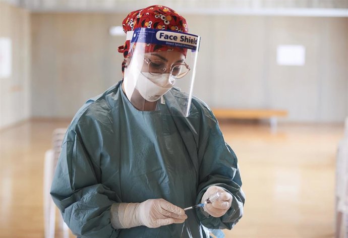 Archivo - Una profesional sanitaria sostiene un vial con la vacuna de AstraZeneca