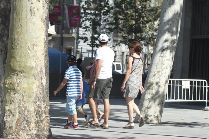 Archivo - Unos padres con su hijo paseando.