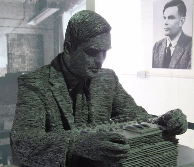 Estatua de Turing  y su retrato de fondo.