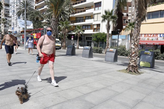 Archivo - Un hombre con mascarilla y bañador camina por el paseo de la playa de La Malagueta. En Málaga (Andalucía, España), a 19 de julio de 2020.