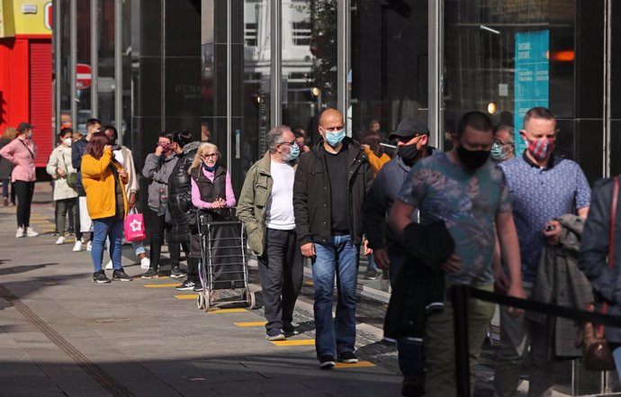 17 May 2021, United Kingdom, Dublin: Shoppers queue in front of a store in Henry Street as Ireland takes another step towards normality with all non-essential retail being allowed to resume. Photo: Niall Carson/PA Wire/dpa
