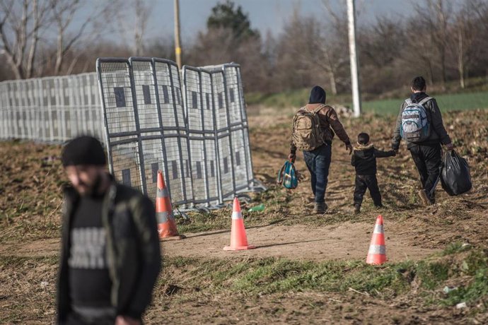 Archivo - Refugiados llevan sus pertenencias al llegar a las puertas del paso fronterizo de Pazarkule, en la frontera turco-griega. 