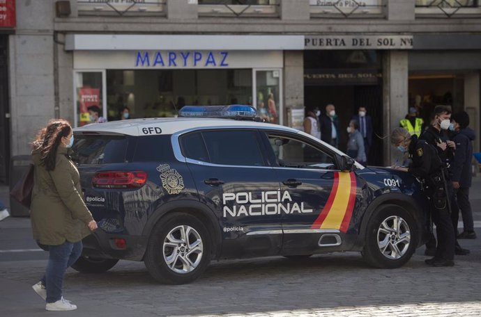 Archivo - Un coche de Policía Nacional circula por la Puerta del Sol, Madrid