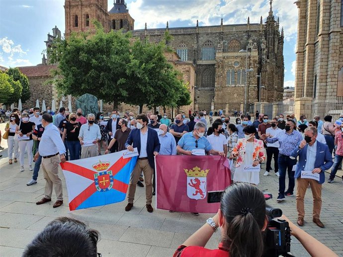 El candidato a presidir el PP de León, Manuel García, sostiene las banderas de León y El Bierzo.