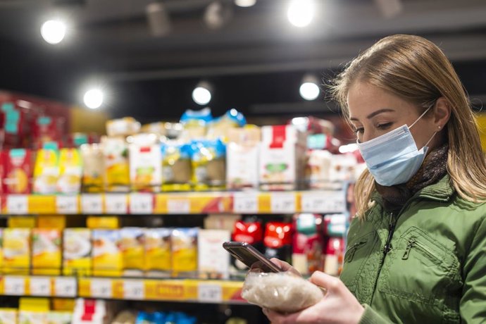 Archivo - Imagen de una mujer con mascarilla en un supermercado.