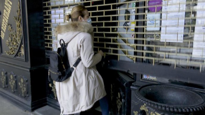 Archivo - Una hostelera abre la persiana de su negocio en Bilbao.